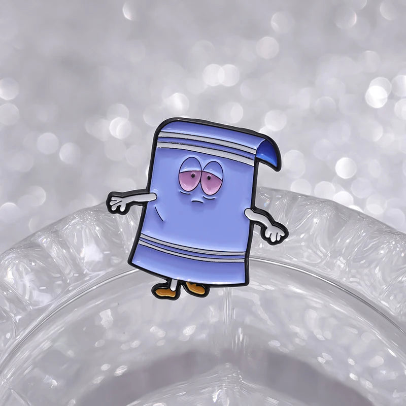 A cartoon towel enamel pin with a purple body and blue stripes, looking surprised.
