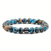 A bracelet made of polished tiger eye lava map beads in shades of black, white, and blue.