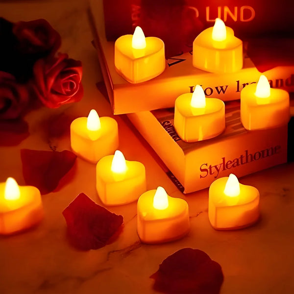 Collection de bougies votives LED jaunes lumineuses, teintes sarcelle, disposées sur un marbre avec des roses et un livre.