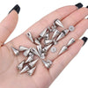 A hand holds a collection of silver punk rock bullet rivets for DIY crafting.