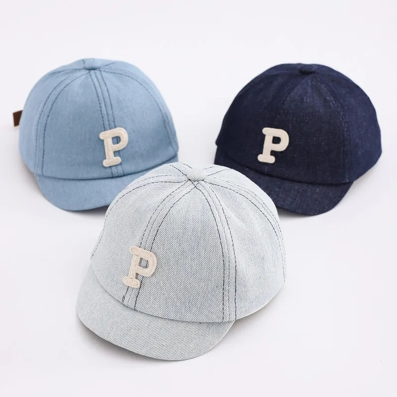 Three denim baseball caps in light blue, dark blue, and gray featuring a tan letter P.