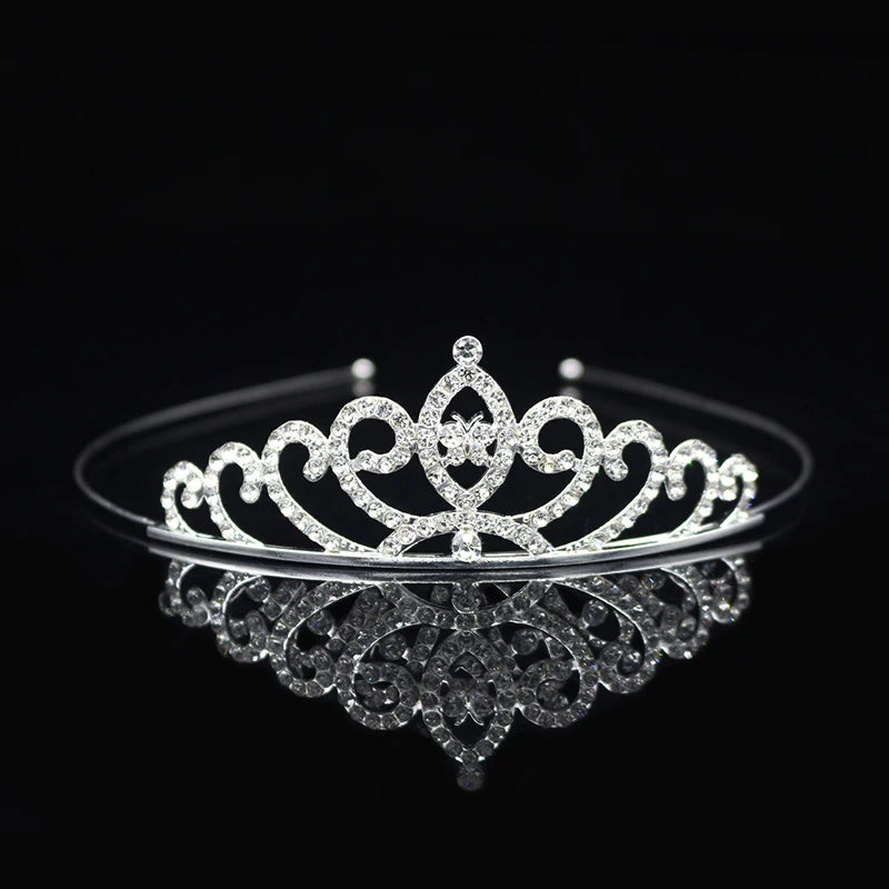 Tiara y corona de princesa de cristal brillante, accesorio para el cabello, mostrada en una superficie reflectante.
