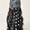 Black satin shawl with white paisley and polka dot floral print tied around dark hair
