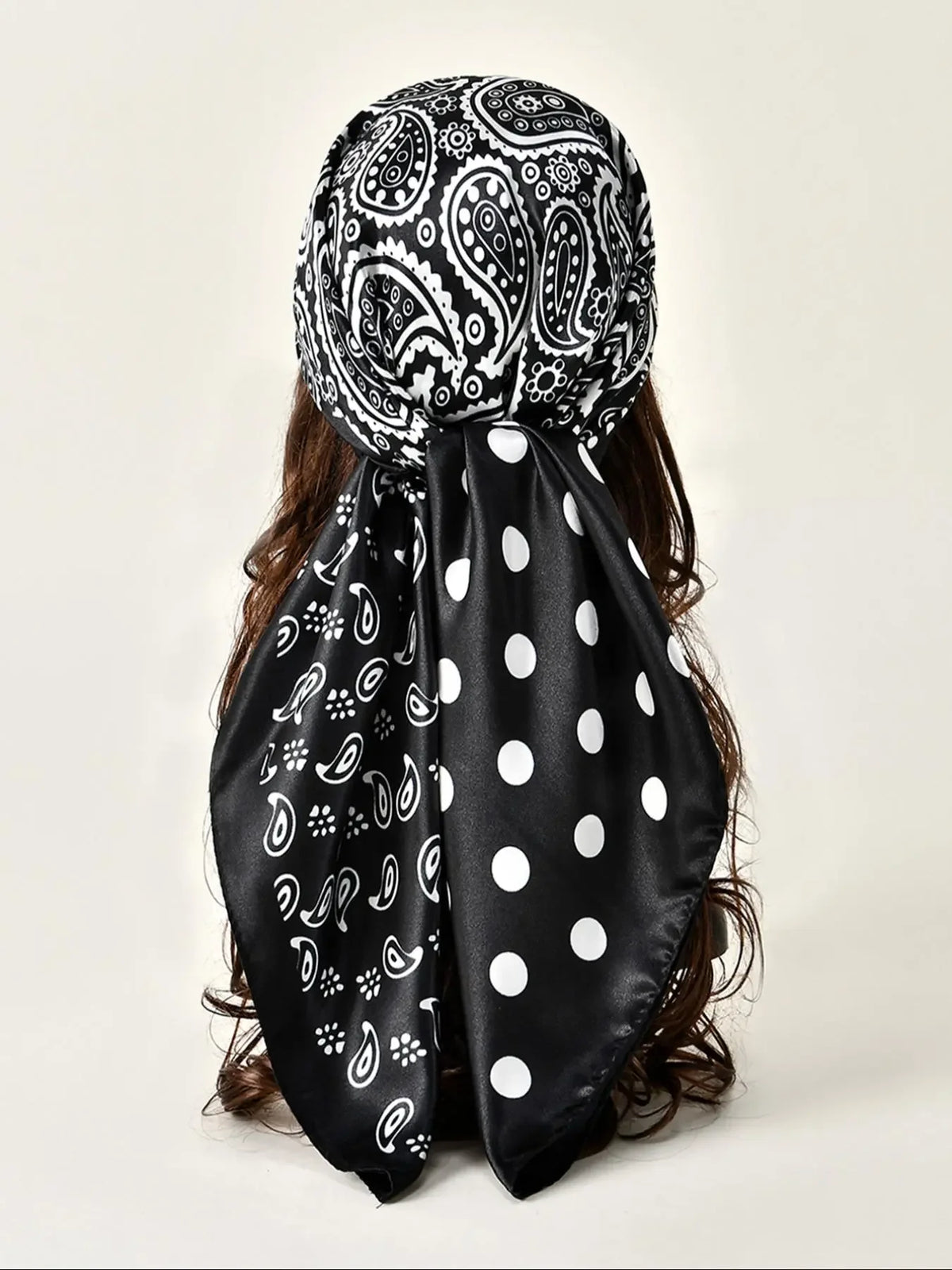 Black satin shawl with white paisley and polka dot floral print tied around dark hair