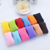 A collection of multi-colored cotton elastic hair ties in various shades including yellow, green, red, blue, orange, purple, 