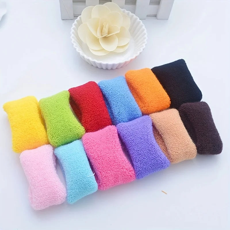 A collection of multi-colored cotton elastic hair ties in various shades including yellow, green, red, blue, orange, purple, 