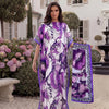 A woman models a purple and white tropical floral print abaya scarf outdoors in front of a white building.