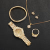 A set of gold-toned jewelry including a bangle, necklaces, earrings, and a watch on a black background.