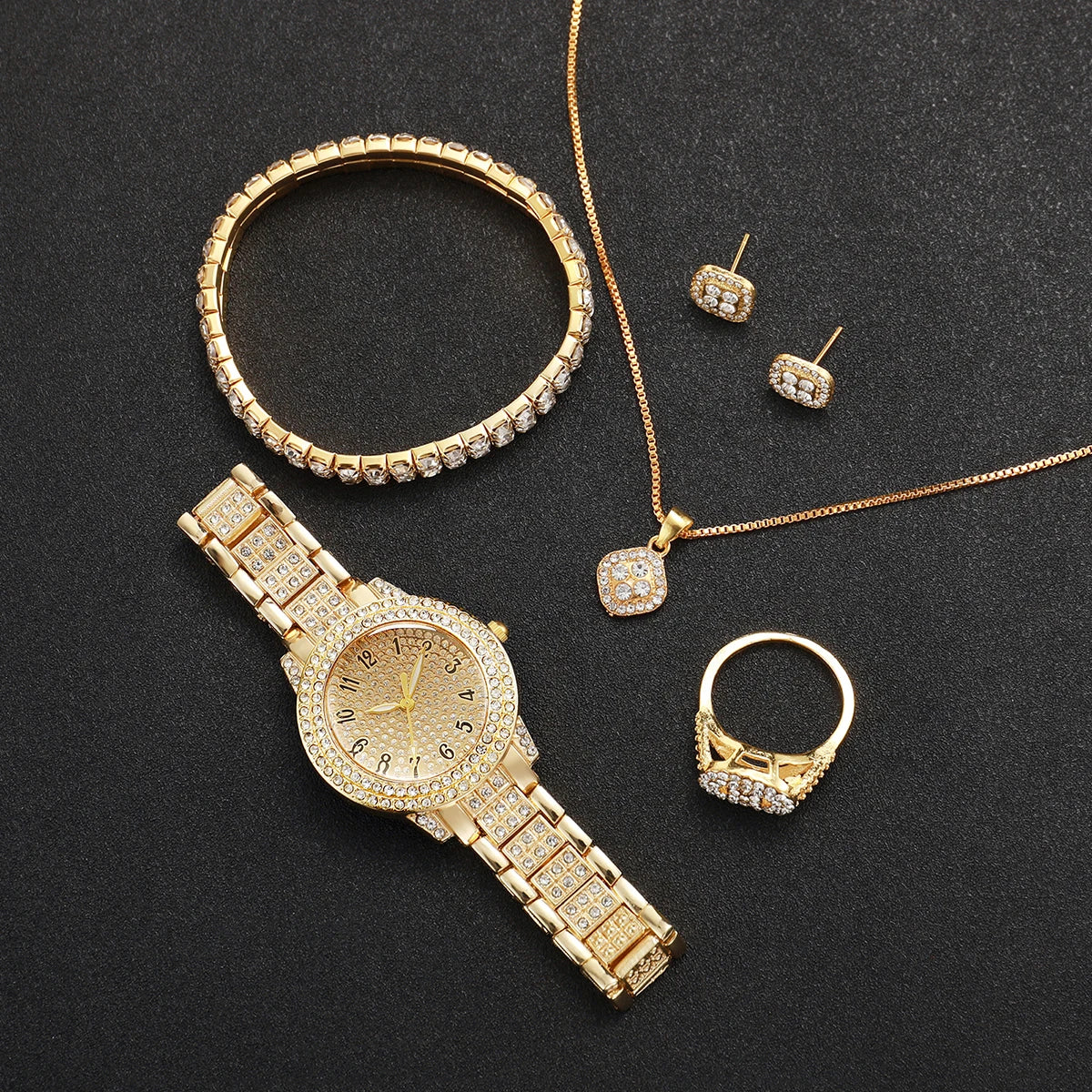 A set of gold-toned jewelry including a bangle, necklaces, earrings, and a watch on a black background.