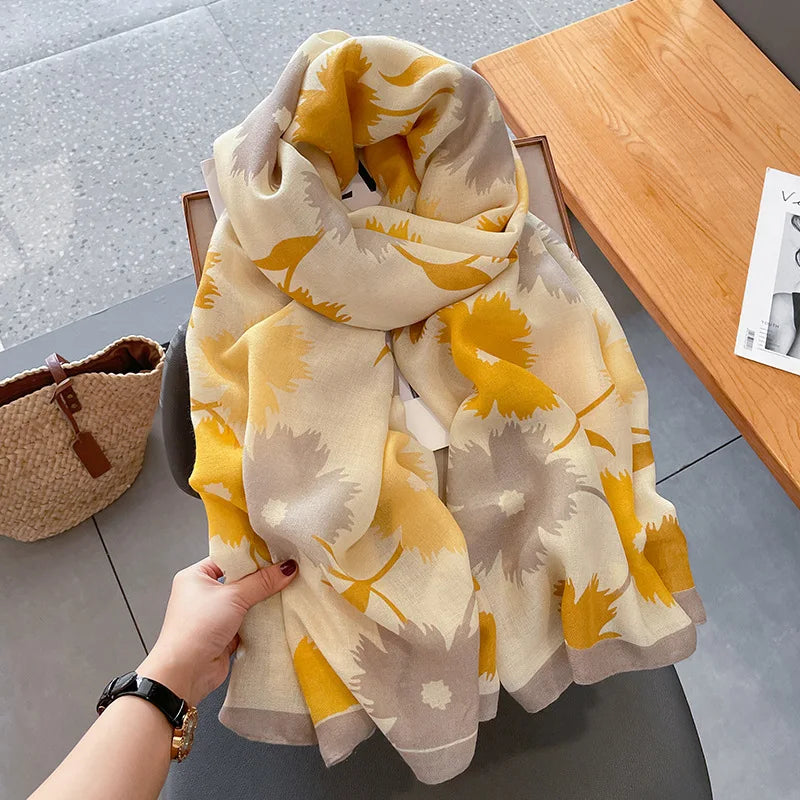 Beige und gelbes florales Pashmina-Schal auf Holzoberfläche.