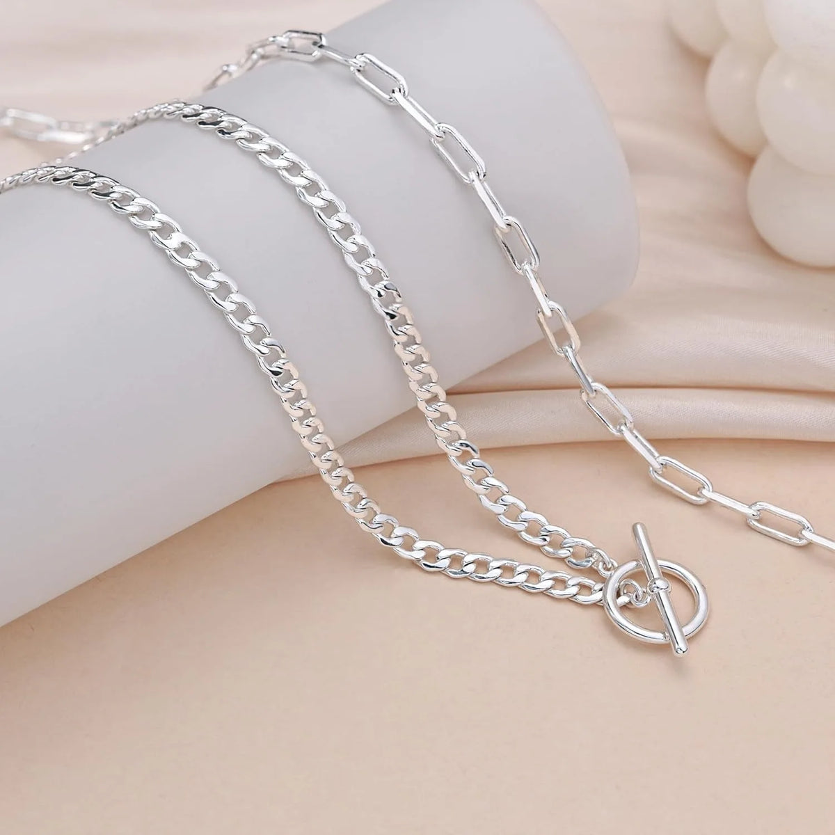 Silver layered Cuban link necklace displayed on a light background.