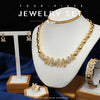 A gold necklace with initial letters spelled out in crystals displayed on a white mannequin.