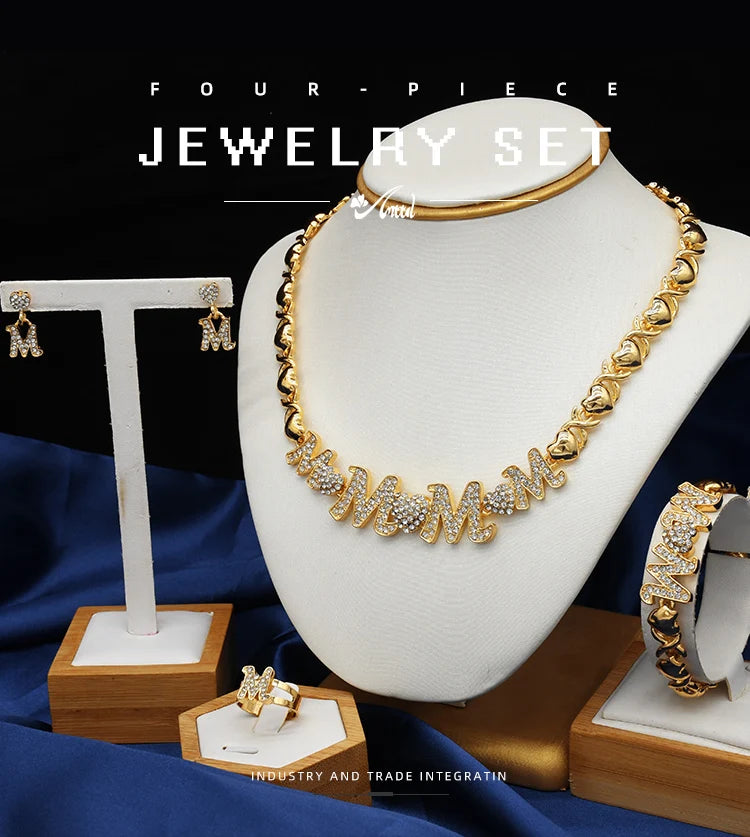 A gold necklace with initial letters spelled out in crystals displayed on a white mannequin.