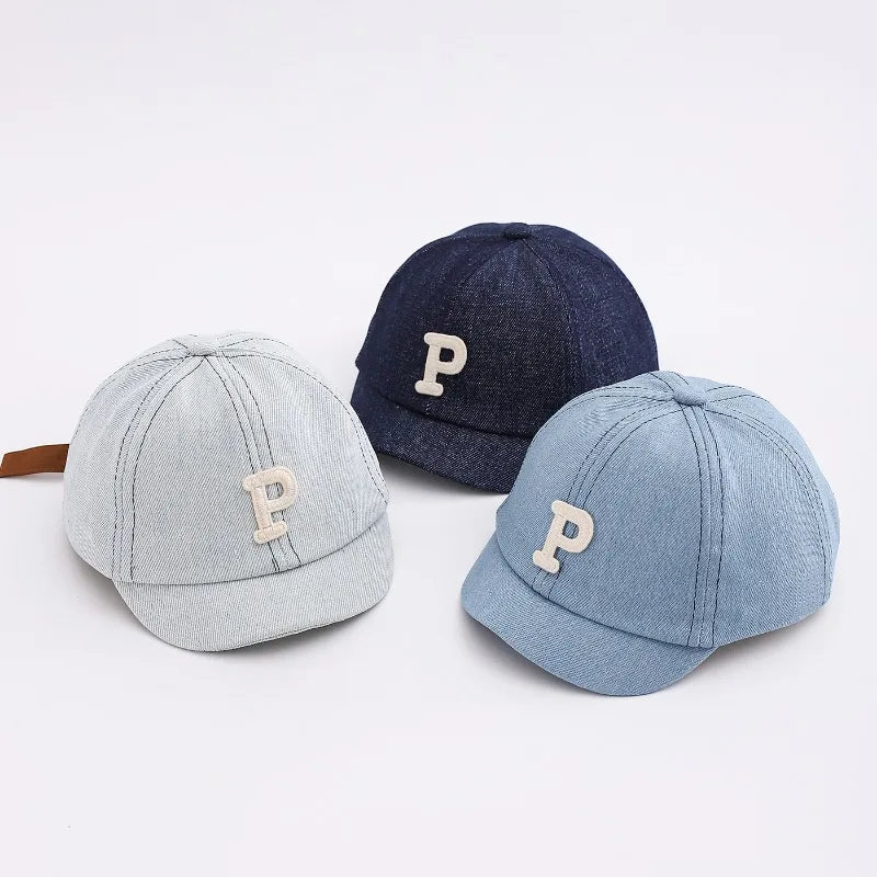 A pair of denim baseball caps, one dark blue and one light blue, featuring a stitched letter P.