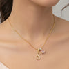 A delicate gold chain necklace with a personalized letter pendant featuring a pink gemstone.