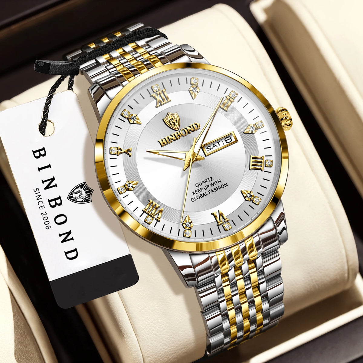 A silver and gold quartz wristwatch with a metal bracelet is displayed on a light-colored box.
