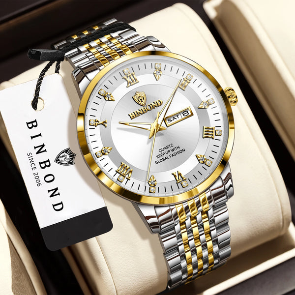 A silver and gold quartz wristwatch with a metal bracelet is displayed on a light-colored box.