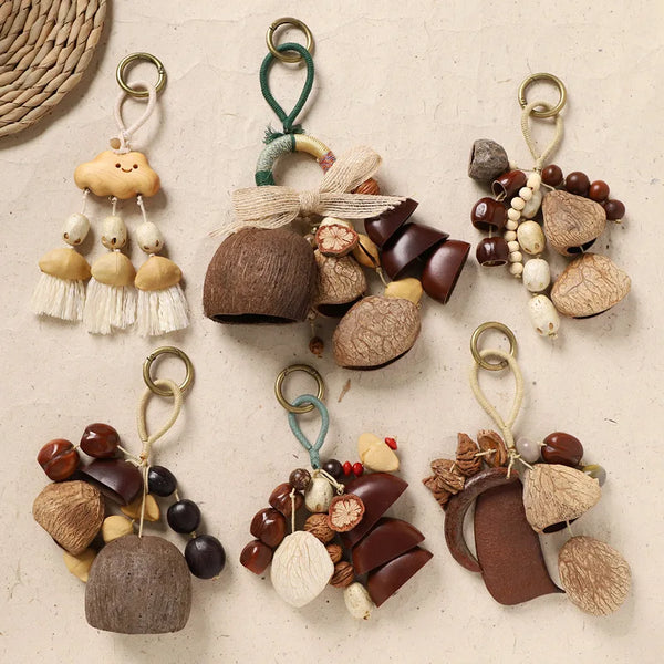 A collection of hand-cranked fruit shell wind chimes and natural wood items used as keychains.