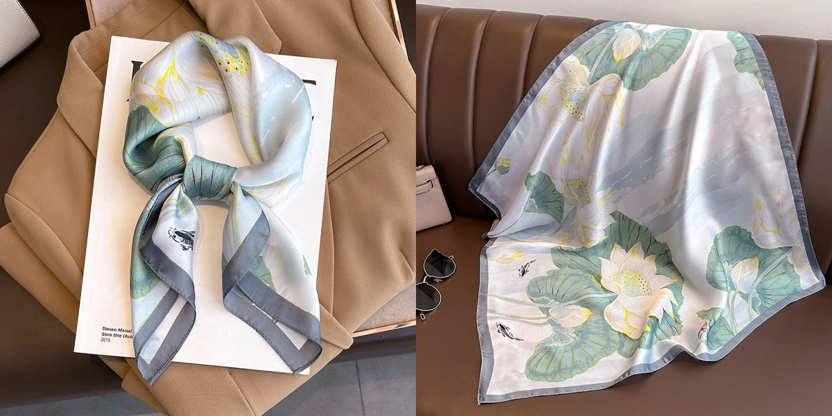 A light blue and green floral print silk scarf draped on a beige jacket.