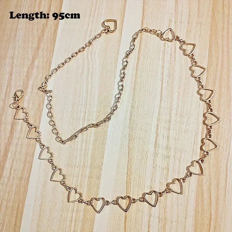 A delicate gold-tone chain necklace featuring heart-shaped charms, displayed on a light wooden surface.