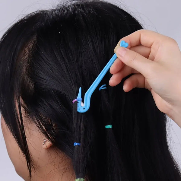 A hand is using a blue tool to remove an elastic or rubber band from a black hair strand.