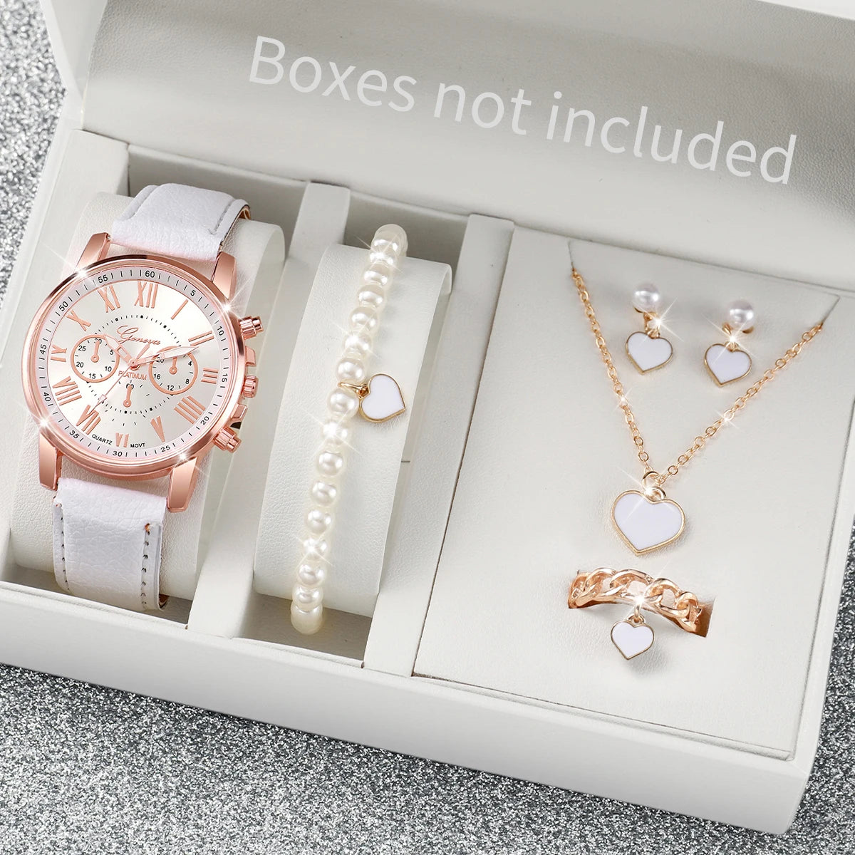 A box contains a pink quartz wristwatch with a leather strap, a pearl necklace, and a gold heart pendant.