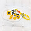 A collection of five yellow fitness keychains and weightlifting accessories on a white plate.