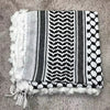 Pañuelo de algodón gris y blanco con estampado, bordado geométrico negro y flecos blancos.