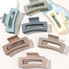 A set of seven square hair claw clips in various muted pastel and neutral colors displayed on a white background.