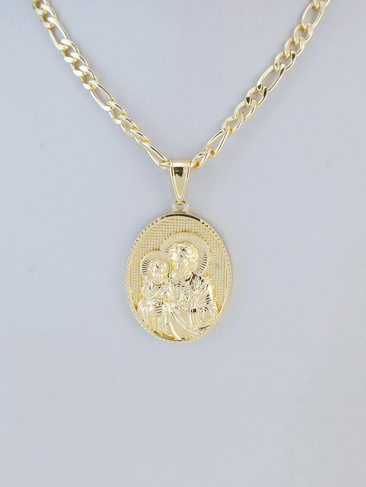 A gold-plated pendant necklace featuring a depiction of the Virgin Mary and Christ.