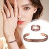 A woman models a set of vintage flower engraved copper bracelets and rings on her hand and wrist.