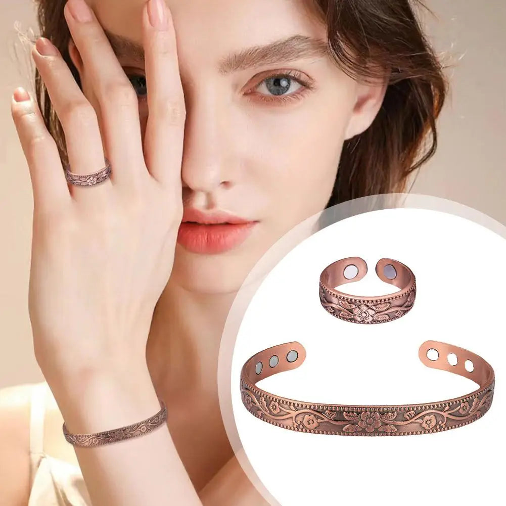 A woman models a set of vintage flower engraved copper bracelets and rings on her hand and wrist.