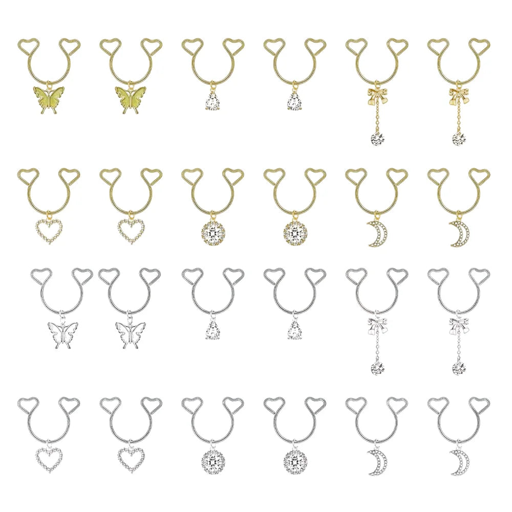 A collection of heart-shaped dangle non-piercing nipple rings with cubic zirconia in gold and silver tones.