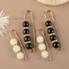 A set of heavy duty pearl safety pins featuring black and white beads for clothing