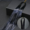 Long black hair extensions with blue glitter strands displayed on a dark surface.