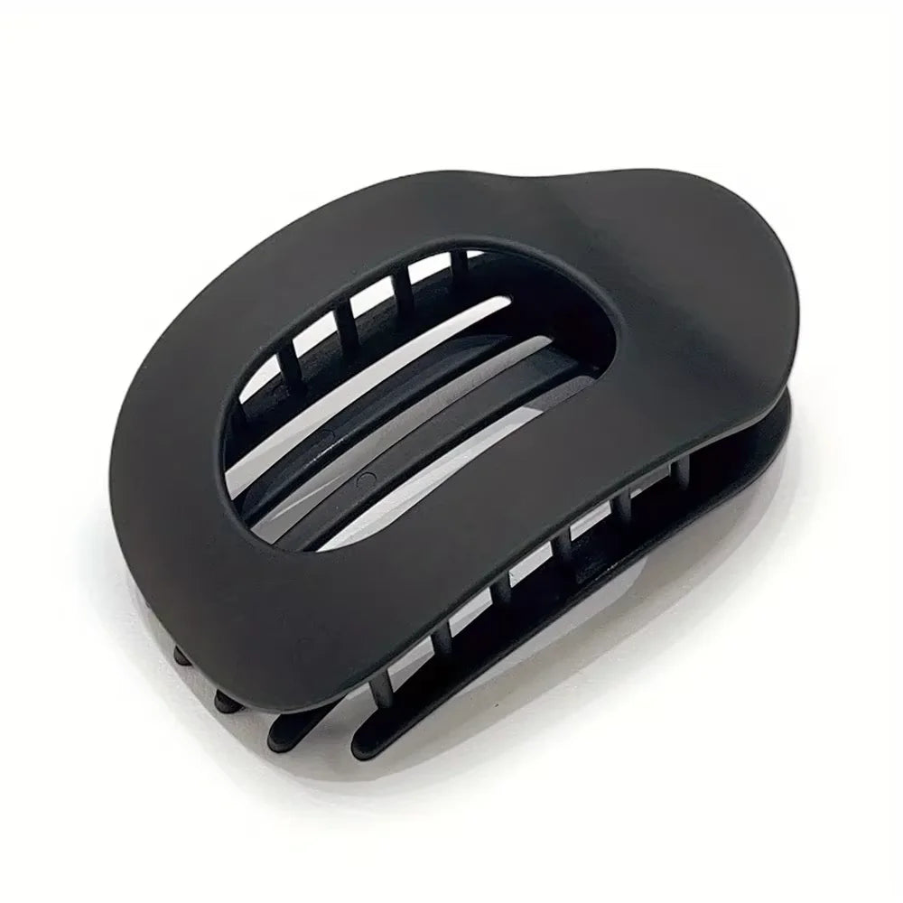 Black matte oval hair claw clip with a slotted design