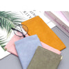 A collection of various colored PU leather glasses cases and storage bags arranged on a gray surface.