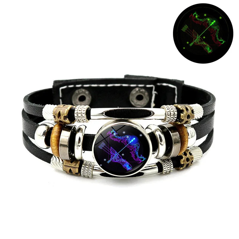 Schwarzes Lederarmband mit silbernen Perlen, goldenen Akzenten und einem zentralen dunklen Stein mit leuchtend violetten Lini