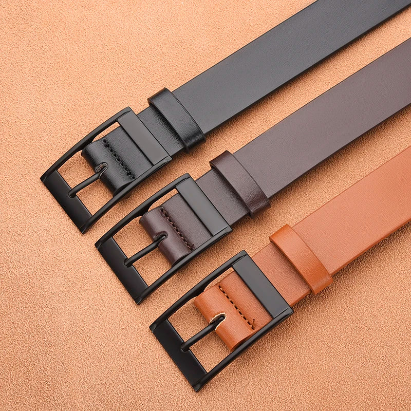 A close-up of a brown leather belt with a black buckle lying on a tan surface.