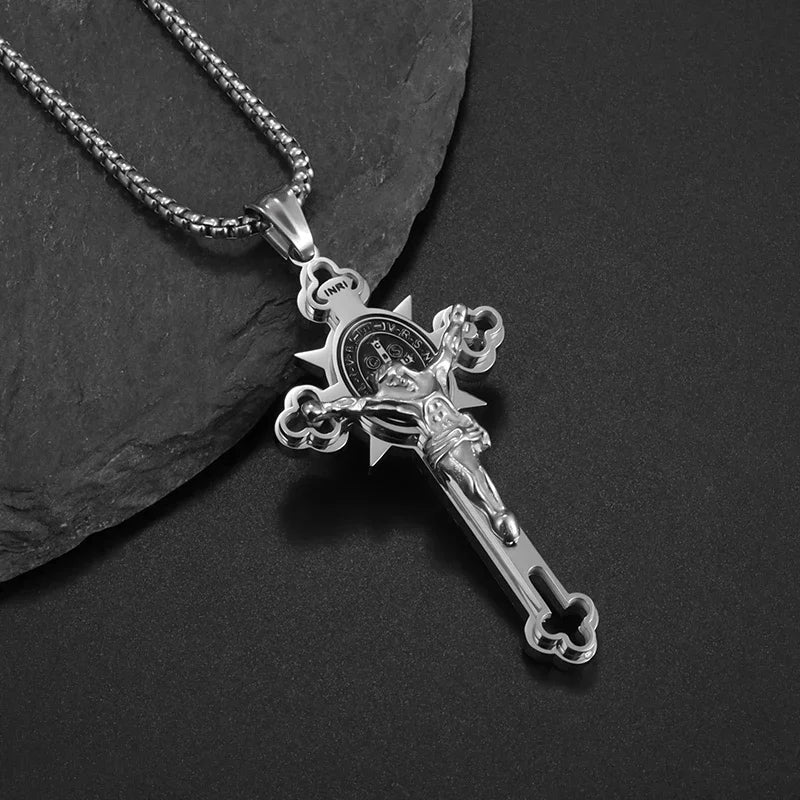 Silver retro Christian cross amulet necklace resting on a dark surface.