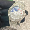 A close-up shot of a luxury quartz wristwatch with a silver-toned metal band and diamond accents, featuring an American flag 