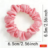 A circular wreath of pink satin fabric scrunchies with ruffled edges.