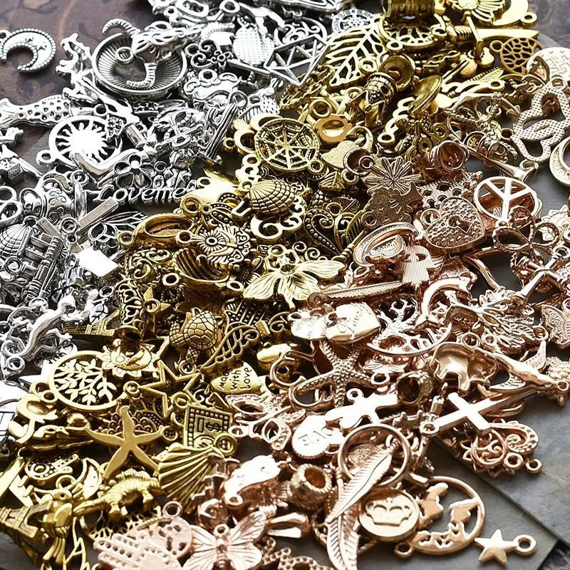 Nahaufnahme verschiedener tibetischer silberner Anhänger und Komponenten für DIY-Schmuck, die verschiedene Texturen zeigen