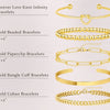A collection of various gold beaded, paperclip, bangle cuff, and Cuban link bracelets.