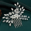 Peigne pour cheveux de mariée en cristal argenté avec perles et cristaux clairs sur un plateau vert foncé.