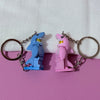 A pair of heart-shaped building block keychains featuring blue and pink shark figures attached to silver split rings.