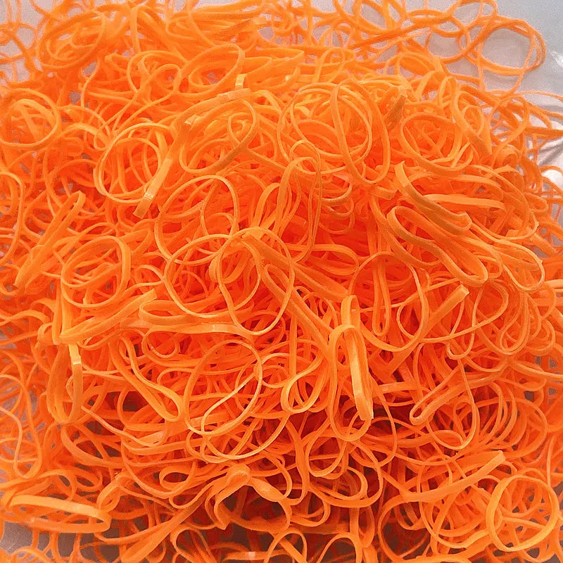 A pile of colorful orange disposable hair scrunchies for ponytail holders.