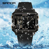 A black digital wristwatch with a luminous display is shown being splashed by water droplets.