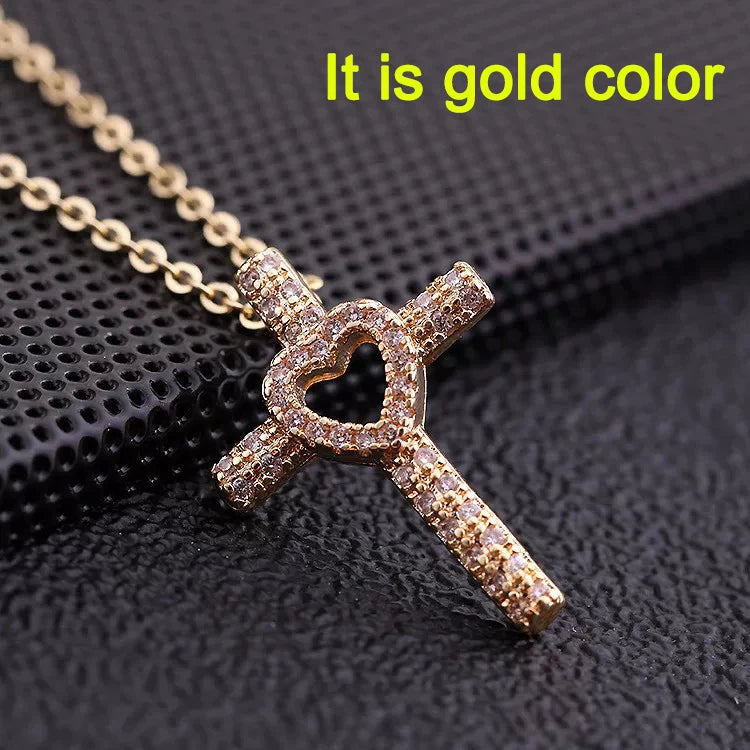 Gold color dainty cross charm necklace on a black background