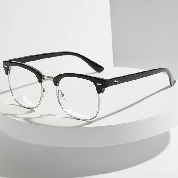 A pair of black-framed eyeglasses with clear lenses resting on a white surface.